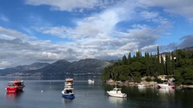 Tekneler ve yatlar yeşil dağ kıyısının yakınındaki denize demirlemiştir. Yüksek kalite 4k görüntü