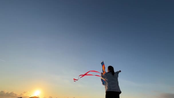 一个在天空下放着彩色风筝的女孩 慢动作高质量的4K镜头 — 图库视频影像