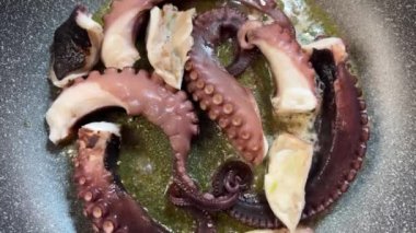 Dilimlenmiş pembe ahtapot dokunaçları yağda pişiyor. Yüksek kalite 4k görüntü