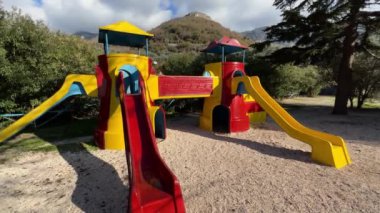 Küçük kız oyun parkında oyuncak kale şeklinde kayarak aşağı kayıyor. Yüksek kalite 4k görüntü