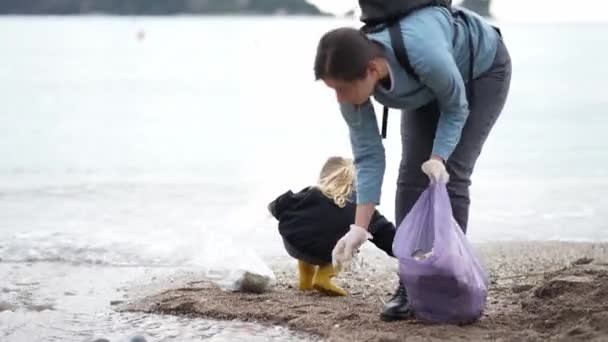 母親と少女は海岸でプラスチックごみを収集します 高品質4K映像 — ストック動画