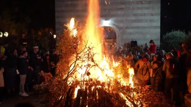 成群的人把成捆的树枝扔进教堂附近的大火中 高质量的4K镜头 — 图库视频影像
