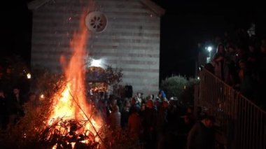 İnsanlar kilise bahçesindeki büyük bir yangına dallar taşıyorlar. Yüksek kalite 4k görüntü