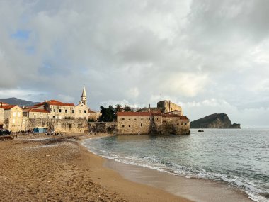 Eski Budva kasabasının taş kale duvarının yanındaki kumsalda. Karadağ. Yüksek kalite fotoğraf
