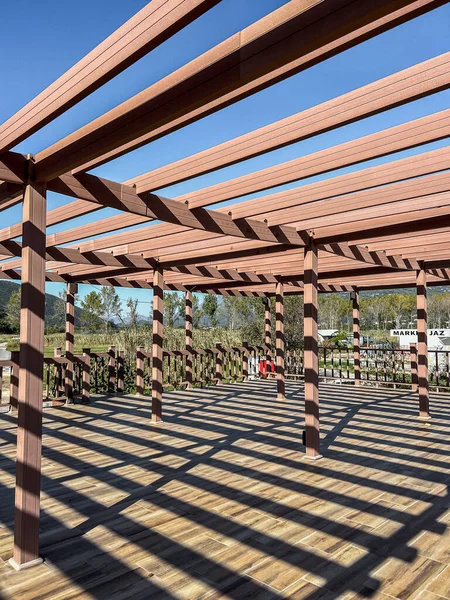 Large wooden pergola with cross beams and terrace. High quality photo