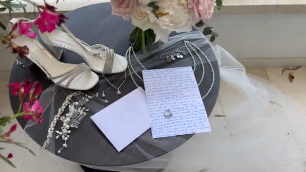 Yüksek Topuklu Ayakkabılar Yüzüğün Yanındaki Masada Mücevherler Bir Buket Çiçek — Stok video