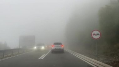 Dağlardaki yoğun siste arabalar otoyol boyunca ilerler. Yüksek kalite 4k görüntü