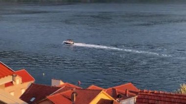 Körfezden geçen bir motorlu teknenin kırmızı kiremitli çatılarına bakın. Yüksek kalite 4k görüntü