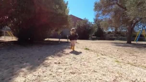 小さな女の子がブランコに向かって遊び場を走っています スローモーション 高品質4K映像 — ストック動画