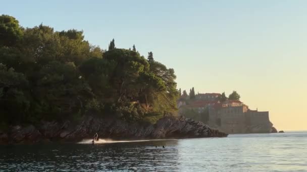 Turista Vodním Skútru Plave Kolem Skalnatého Pobřeží Ostrova Sveti Stefan — Stock video