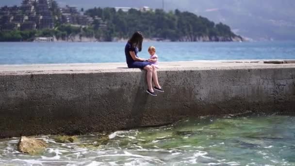 Μαμά Μια Μικρή Κόρη Κάθονται Ένα Κυματοθραύστη Στη Θάλασσα Υψηλής — Αρχείο Βίντεο
