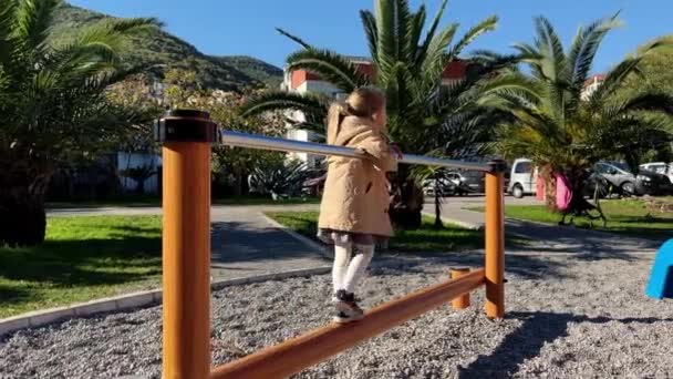 Little Girl Walks Beam Holding Handrail Playground High Quality Footage — ストック動画
