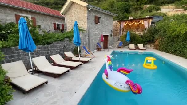 Multi Gekleurde Opblaasbare Speelgoed Drijven Het Zwembad Buurt Van Ligstoelen — Stockvideo