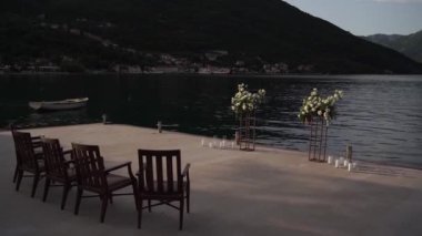 Çiçek buketlerinin yarı kemeri iskemlelerin yanındaki iskelede duruyor. Yüksek kaliteli FullHD görüntüler