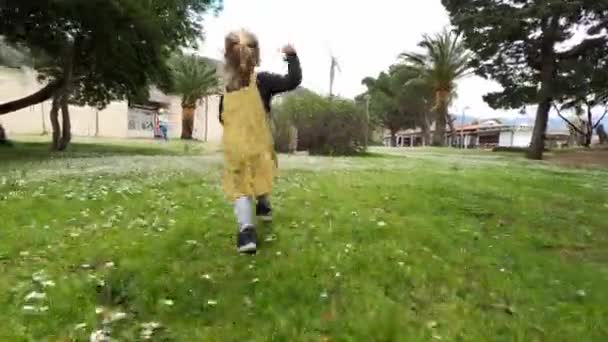 Маленькая Девочка Бежит Цветущей Лужайке Машет Рукой Женщине Идущей Ней — стоковое видео