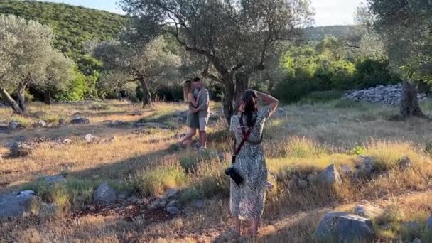 Kız Fotoğrafçı Parkta Bir Ağacın Altında Sarılan Kadın Erkeğin Fotoğraflarını — Stok video