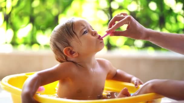 Mamãe Escova Dentes Para Uma Menina Sentada Uma Tigela Água — Vídeo de Stock