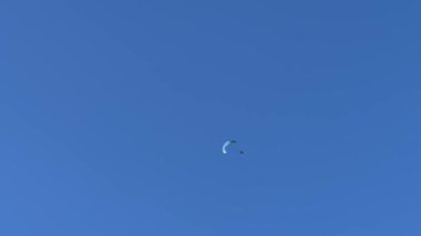 Parasailer mavi gökyüzünde paraşütle süzülüyor. Yüksek kalite 4k görüntü