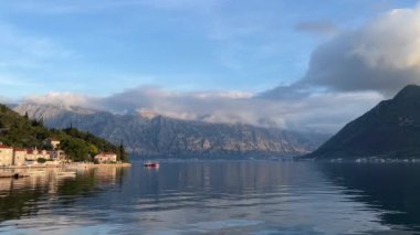 Perast kıyısında, gün batımında yeşil dağların eteklerinde. Karadağ. Yüksek kalite 4k görüntü