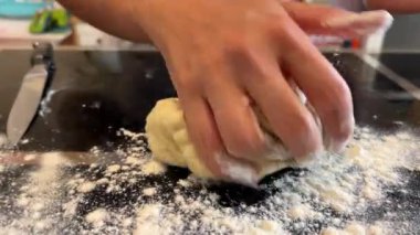 Kadın masaya un serper ve hamuru yoğurur. Yüksek kalite 4k görüntü