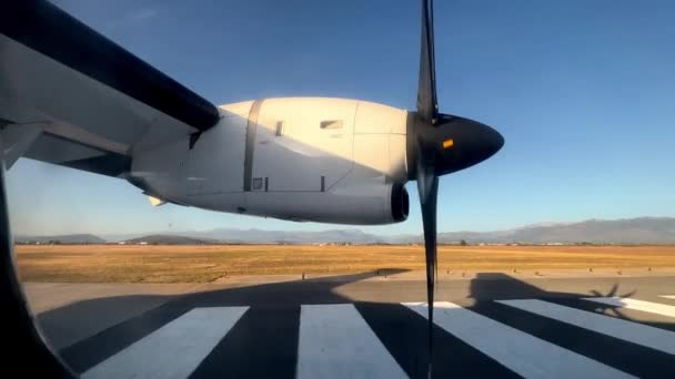 滑走路に沿って移動する航空機の回転プロペラのポートホールからの眺め 高品質4K映像 — ストック動画