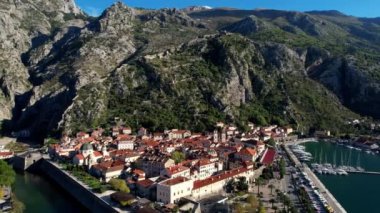 Deniz kıyısındaki dağların eteklerinde yatları olan bir iskelesi olan antik Kotor kasabası. Drone. Yüksek kalite 4k görüntü
