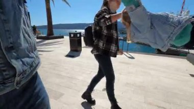 Annem ve babam sette yürüyorlar ve ellerini tutan küçük bir kızı sallıyorlar. Yüksek kalite 4k görüntü