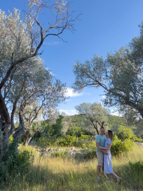 Bahçedeki yeşil ağacın yanında duran gülümseyen adam ve kadın. Yüksek kalite fotoğraf