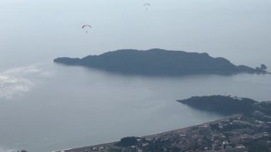 Dağdan paraşütle atlayan paraşütçülere kadar deniz manzarası. Yüksek kalite 4k görüntü