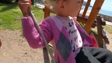 Babam salıncakta küçük bir kız sallıyor. Ağır çekim. Yüksek kalite 4k görüntü