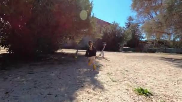 小女孩穿过操场跑到秋千平衡器那里 高质量的4K镜头 — 图库视频影像