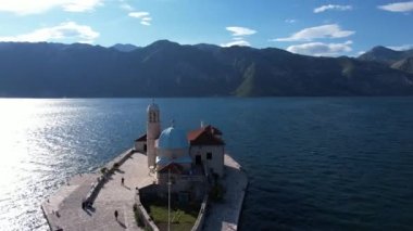 Kotor Körfezi 'ndeki Kayalıklardaki Meryem Kilisesi' nin arka planındaki dağlara karşı. Karadağ. Yüksek kalite 4k görüntü