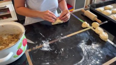 Pastanın kenarlarını kapatan fırıncı, masada çörekler için doldurulmuş. Yüksek kalite 4k görüntü