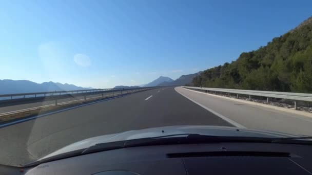 緑の山々の間の高速道路のフロントガラスからの眺め 高品質4K映像 — ストック動画