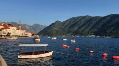 Perast sahilinin yakınındaki iskelede küçük kayıklar denizde kayalar oluşturuyor. Karadağ. Yüksek kalite 4k görüntü