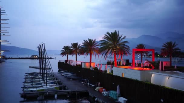 セーリングヨットは夕暮れ時に山を背景に桟橋に立っています 高品質4K映像 — ストック動画
