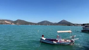Küçük bir turist teknesi, demirleme yerindeki dalgalarda sallanıyor. Yüksek kaliteli FullHD görüntüler