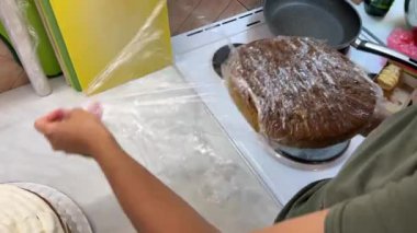 Aşçı bisküvi katmanından yapışkan filmi çıkarır. Yüksek kalite 4k görüntü