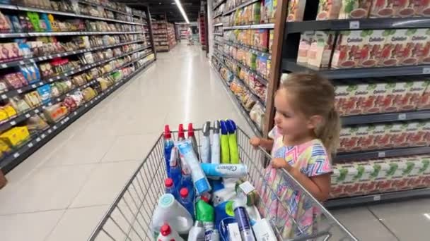 Tata Jeździ Małą Dziewczynką Trzymającą Się Wózka Supermarkecie Wysokiej Jakości — Wideo stockowe