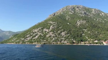 Keşif teknesi dağlık sahil boyunca denizde yüzer. Yüksek kalite 4k görüntü