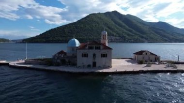 Kayalıklardaki Meryem Ana Kilisesi 'nin Gospa od Skrpjela adasında çan kulesi var. Drone. Yüksek kalite 4k görüntü