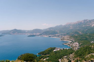 Kotor Körfezi, mavi gökyüzüne karşı açık bir sis bulutuyla çevrili yeşil dağlarla çevrili. Karadağ. Yüksek kalite fotoğraf