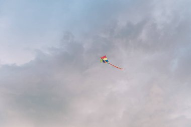 Çok renkli uçurtma bulutlu gökyüzünde yükselir. Yüksek kalite fotoğraf