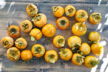 Olgun hurmaların çoğu ahşap bir masanın üzerinde duruyor. Üst Manzara. Yüksek kalite fotoğraf