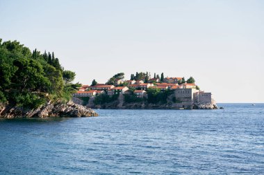 Denizden yeşil pelerinin arkasındaki Sveti Stefan adasına bak. Karadağ. Yüksek kalite fotoğraf