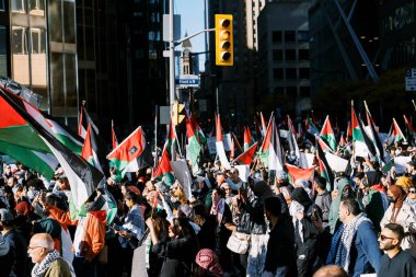 Filistinlilerin Gazze 'deki İsrail saldırısına karşı Toronto' da savaş karşıtı yürüyüş. İsrail-HAMAS savaşını barışçıl bir şekilde protesto ediyor. Protestocular bayrak sallıyor. Filistin soykırımı.