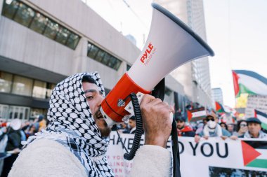 Filistinlilerin Gazze 'deki İsrail saldırısına karşı Toronto' da savaş karşıtı yürüyüş. İsrail-HAMAS savaşını barışçıl bir şekilde protesto ediyor. Protestocular bayrak sallıyor. Filistin soykırımı.