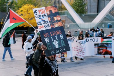 Filistinlilerin Gazze 'deki İsrail saldırısına karşı Toronto' da savaş karşıtı yürüyüş. İsrail-HAMAS savaşını barışçıl bir şekilde protesto ediyor. Protestocular bayrak sallıyor. Filistin soykırımı.