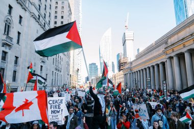 Filistinlilerin Gazze 'deki İsrail saldırısına karşı Toronto' da savaş karşıtı yürüyüş. İsrail-HAMAS savaşını barışçıl bir şekilde protesto ediyor. Protestocular bayrak sallıyor. Filistin soykırımı.