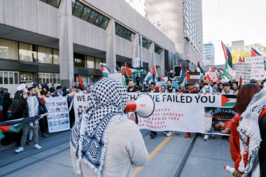 Filistinlilerin Gazze 'deki İsrail saldırısına karşı Toronto' da savaş karşıtı yürüyüş. İsrail-HAMAS savaşını barışçıl bir şekilde protesto ediyor. Protestocular bayrak sallıyor. Filistin soykırımı.